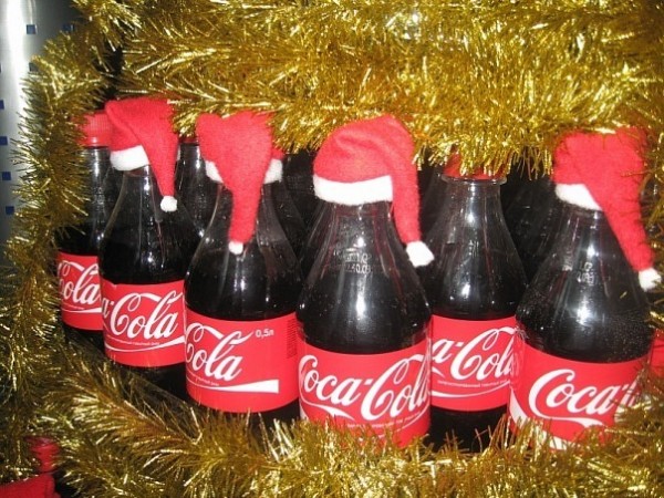 Бутылки кока-колы в новогодних крышечках-шапочках.